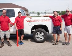 Four employees standing next to the official Trusty-Cook truck.