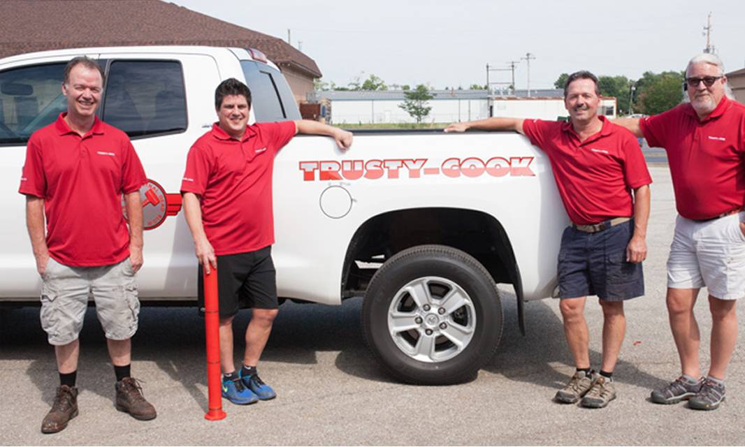 4 employees of Trusty-Cook standing by the official TC truck.